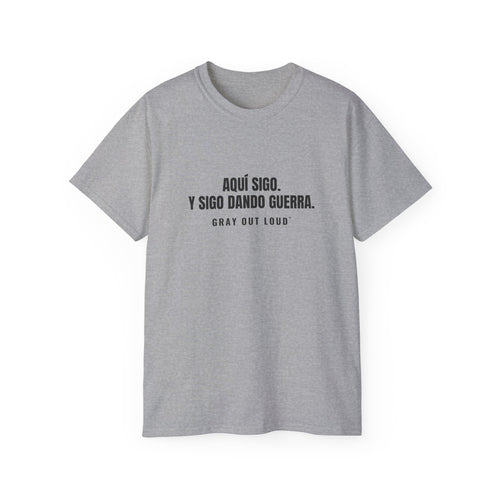Aquí Sigo. Y Sigo Dando Guerra Tee — Gray Out Loud (Spanish)