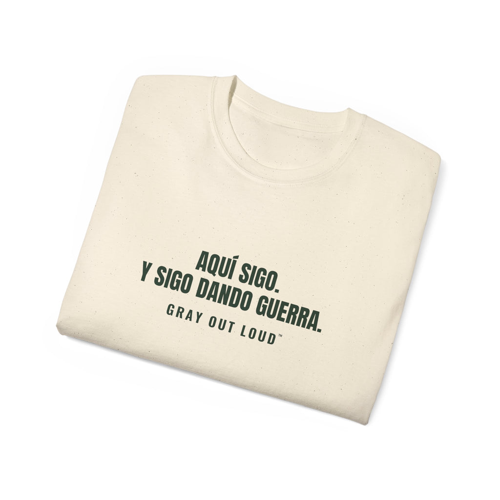 Aquí Sigo. Y Sigo Dando Guerra Tee — Gray Out Loud (Spanish)
